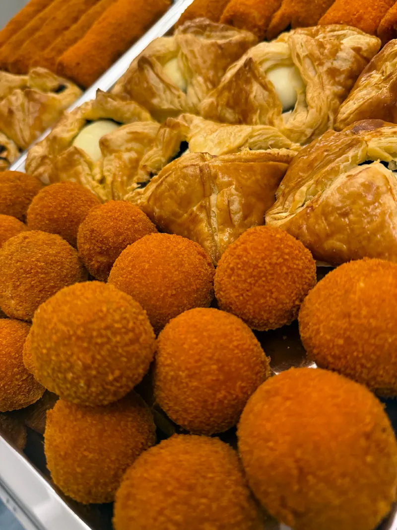 A basket of golden-brown, crispy Sri Lankan short eats, featuring vegetable and meat-filled pastries.