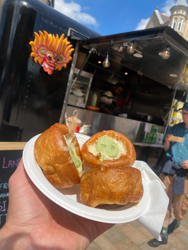 Customer holding The Lankan Fix Yorkie Bombs in front of the food truck.